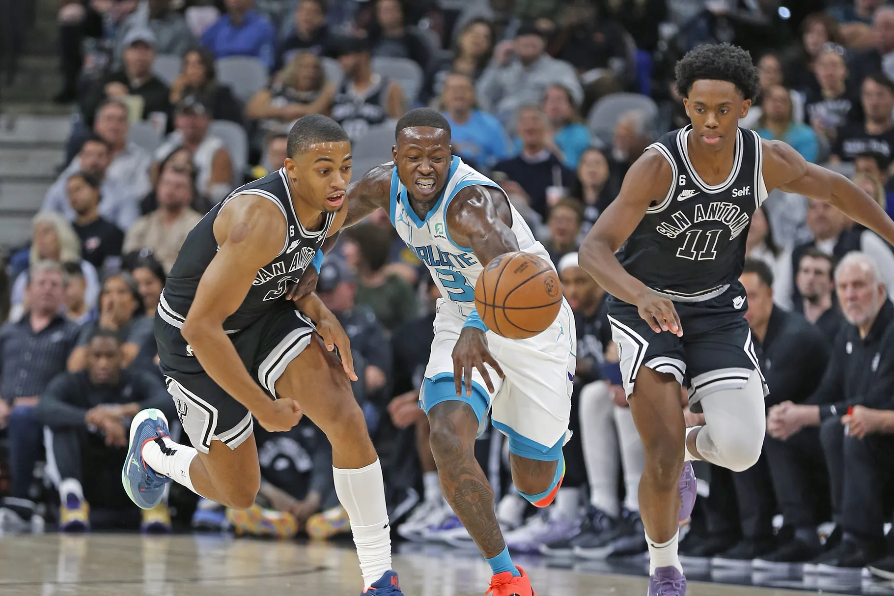Spurs and Hornets players rush to a loose ball